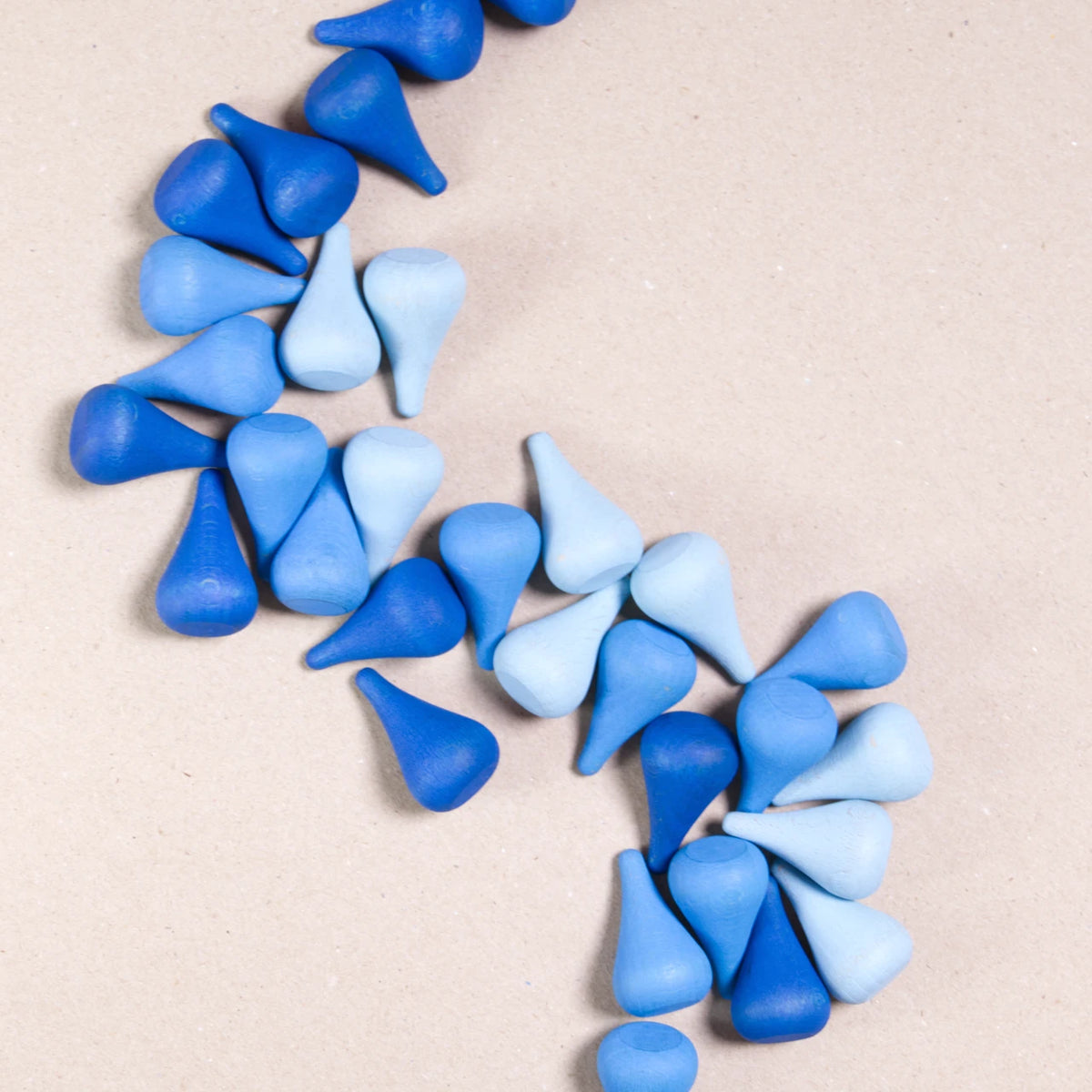 Komposition aus den Figuren aus dem Set Mandala Raindrop von Grapat. Alle Holzfiguren sind blau.