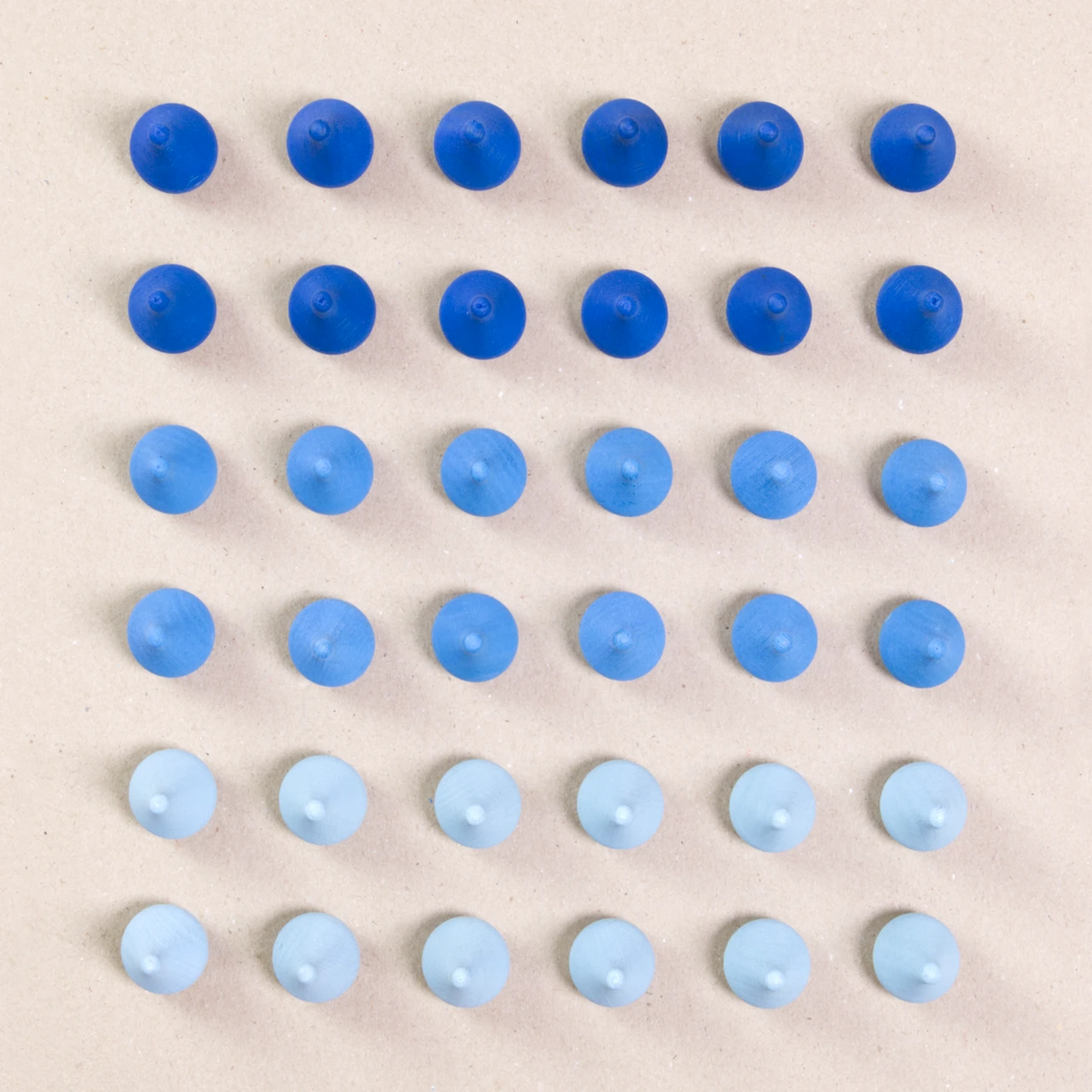 36 Regentropfen Holzfiguren von Grapat in drei unterschiedlichen Farben. Hellblau, blau und dunkelblau. Gemeinsam als Quadratischer Block aufgebaut. Ansicht von Oben.