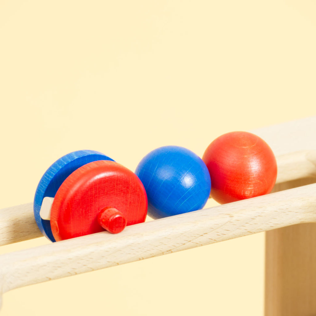 Holz Zubehör der Multibahn, eine blaue Kugel, eine rote Kugel und ein Objekt in blau und rot.