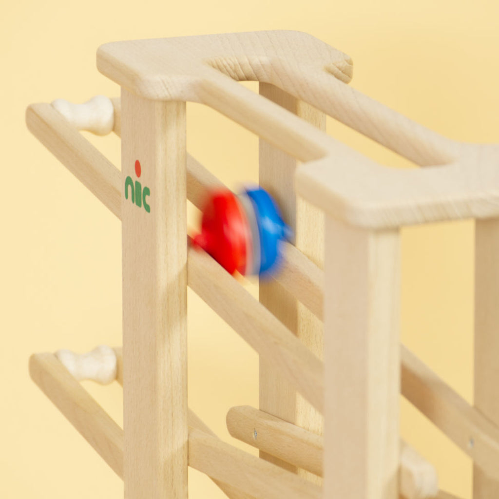 Holz Multibahn mit rollendem Objekt in rot und blau.