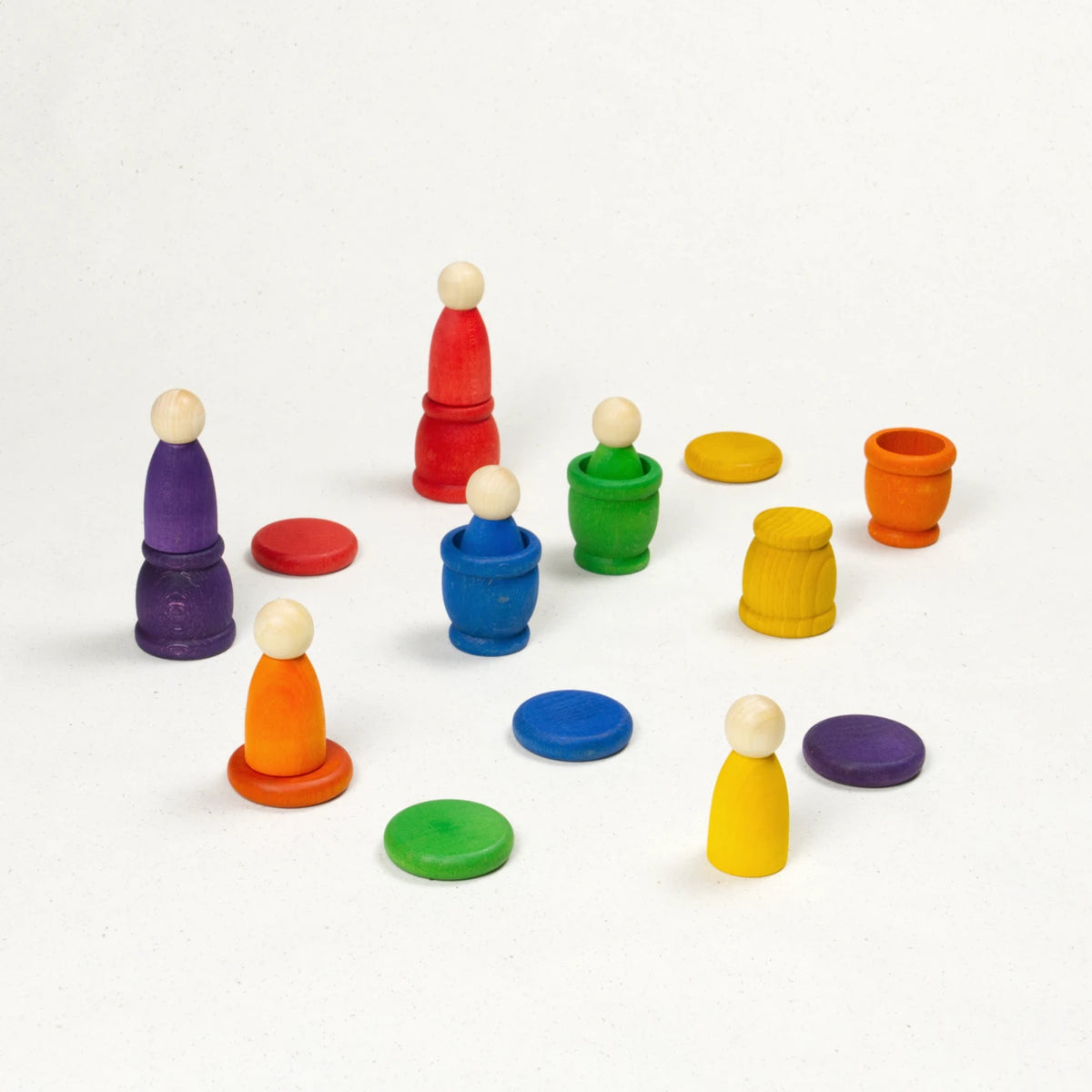 Sechs bunte Nins in und auf farblich passenden Töpfchen mit münzförmigen Deckeln.