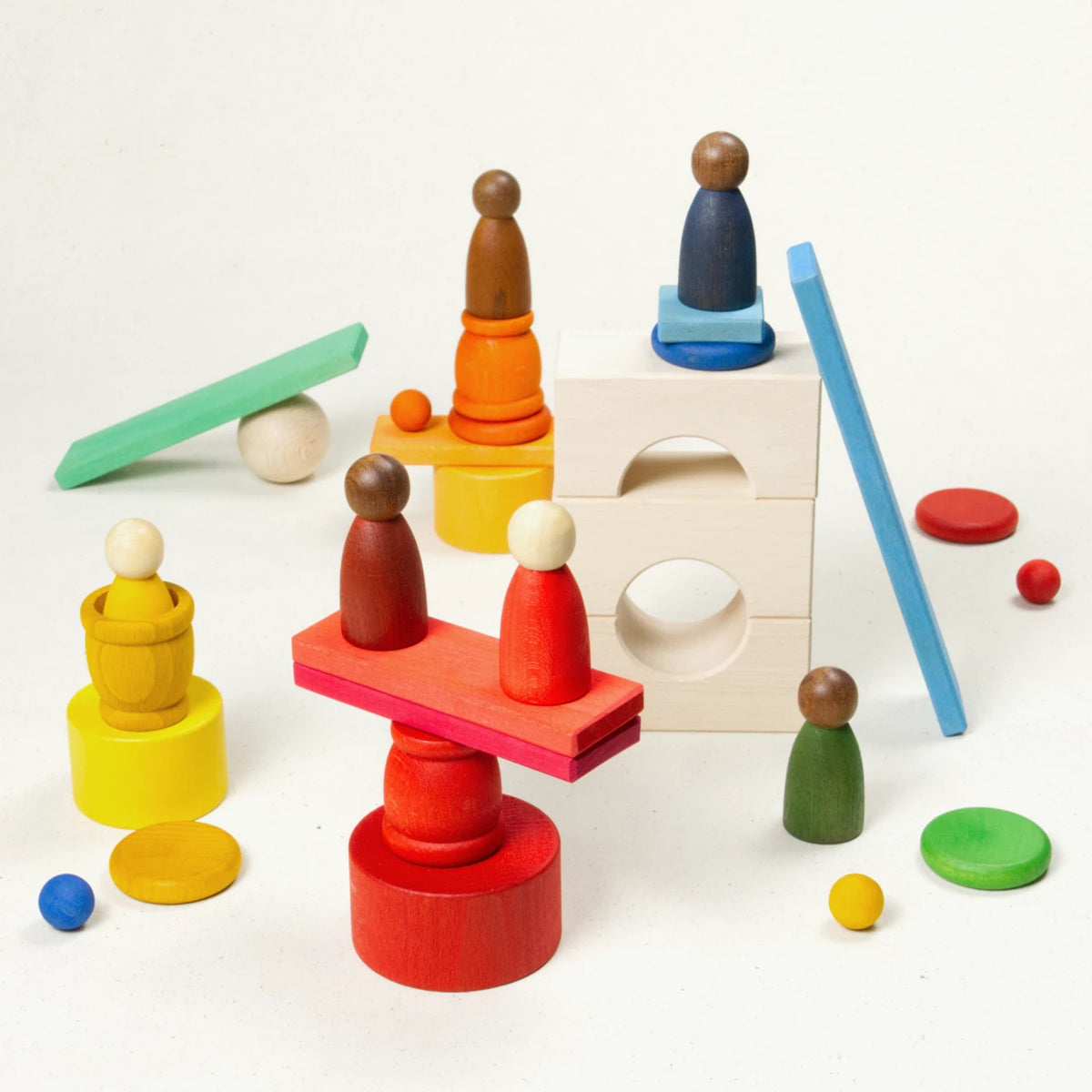Komposition aus sechs gleichförmigen Holzfiguren auf Töpfchen, münzenartigen Deckeln, Holzbausteine und bunten Kugeln sowie Holzplatten.