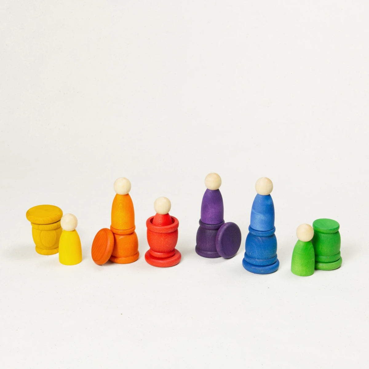 bunte gleichförmige Holzfiguren in ihren bunten Töpfchen mit münzenartigen Deckeln.