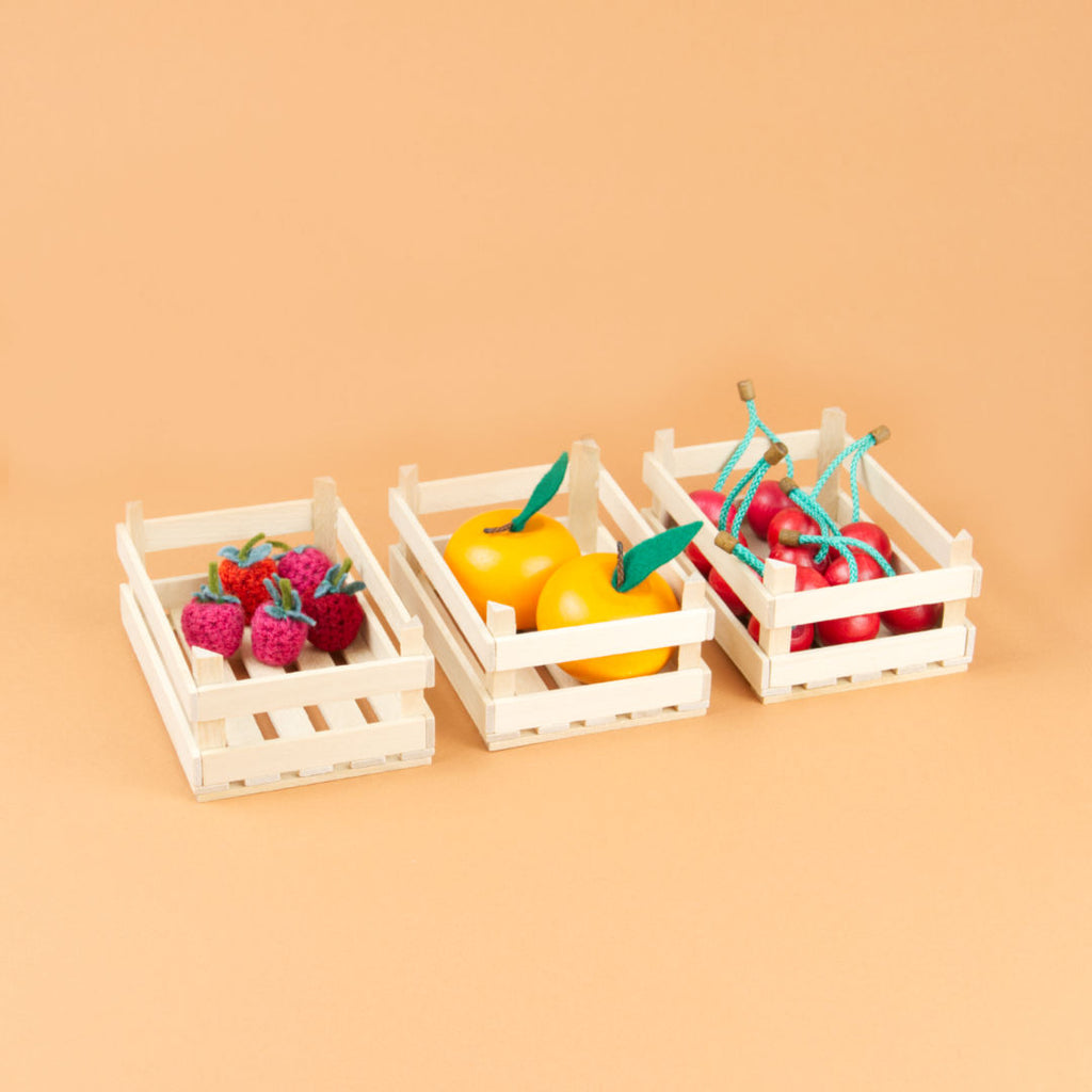 Drei gefüllte, mittelgroße Obststiegen nebeneinander.