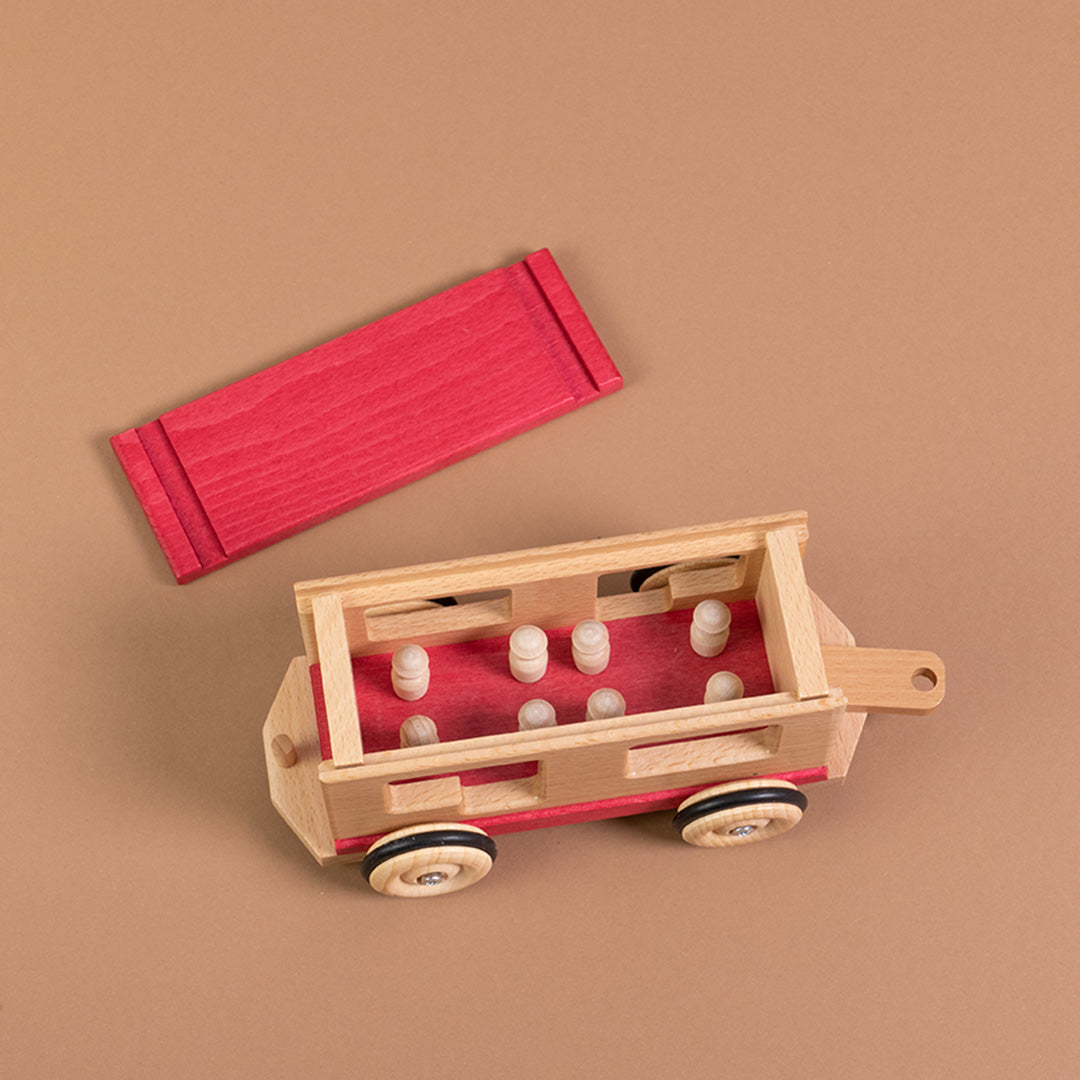 Draufsicht des rollbaren Personenwagens von Beck mit herausnehmbaren Figuren und geöffnetem roten Deckel.