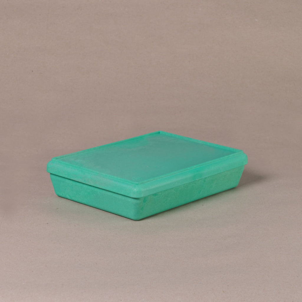 Die aus recyclebarem Material bestehende grüne Box von Wissner, mit geschlossenem Deckel daliegend.
