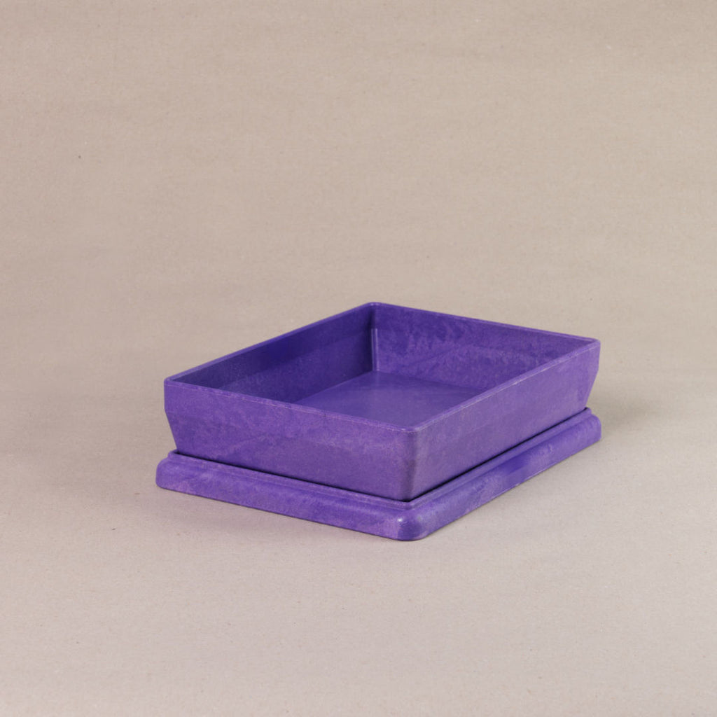 Die aus recyclebarem Material bestehende lila Box von Wissner, mit offenem Deckel daliegend.