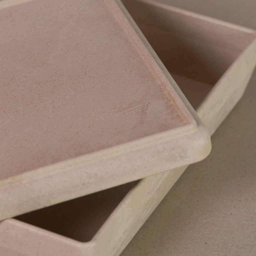 Nahaufnahme von der aus recyclebarem Material bestehende naturfarbenen Box von Wissner, mit halboffenem Deckel daliegend.