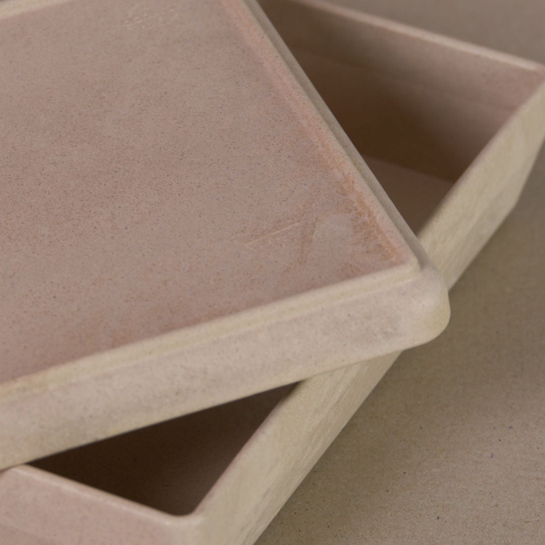 Nahaufnahme von der aus recyclebarem Material bestehende naturfarbenen Box von Wissner, mit halboffenem Deckel daliegend.