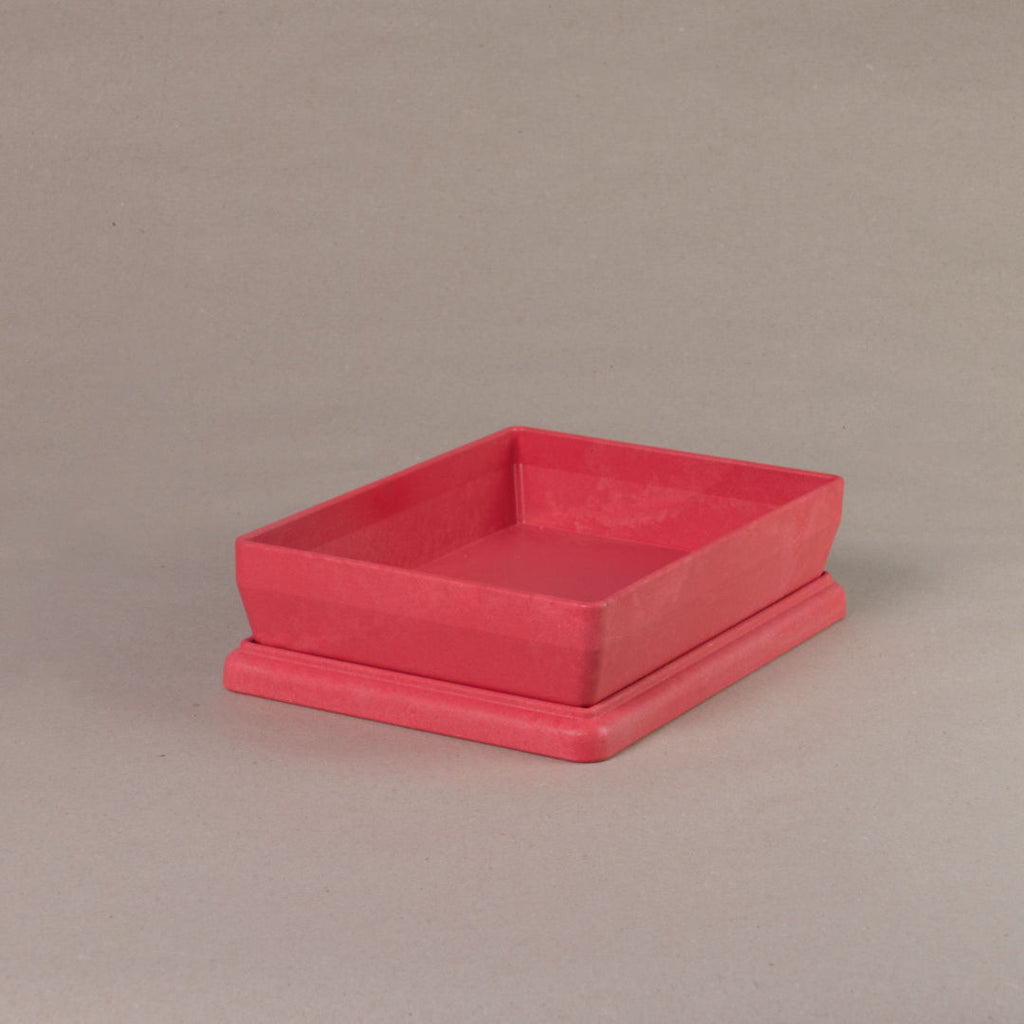 Die aus recyclebarem Material bestehende rote Box von Wissner, mit offenem Deckel daliegend.