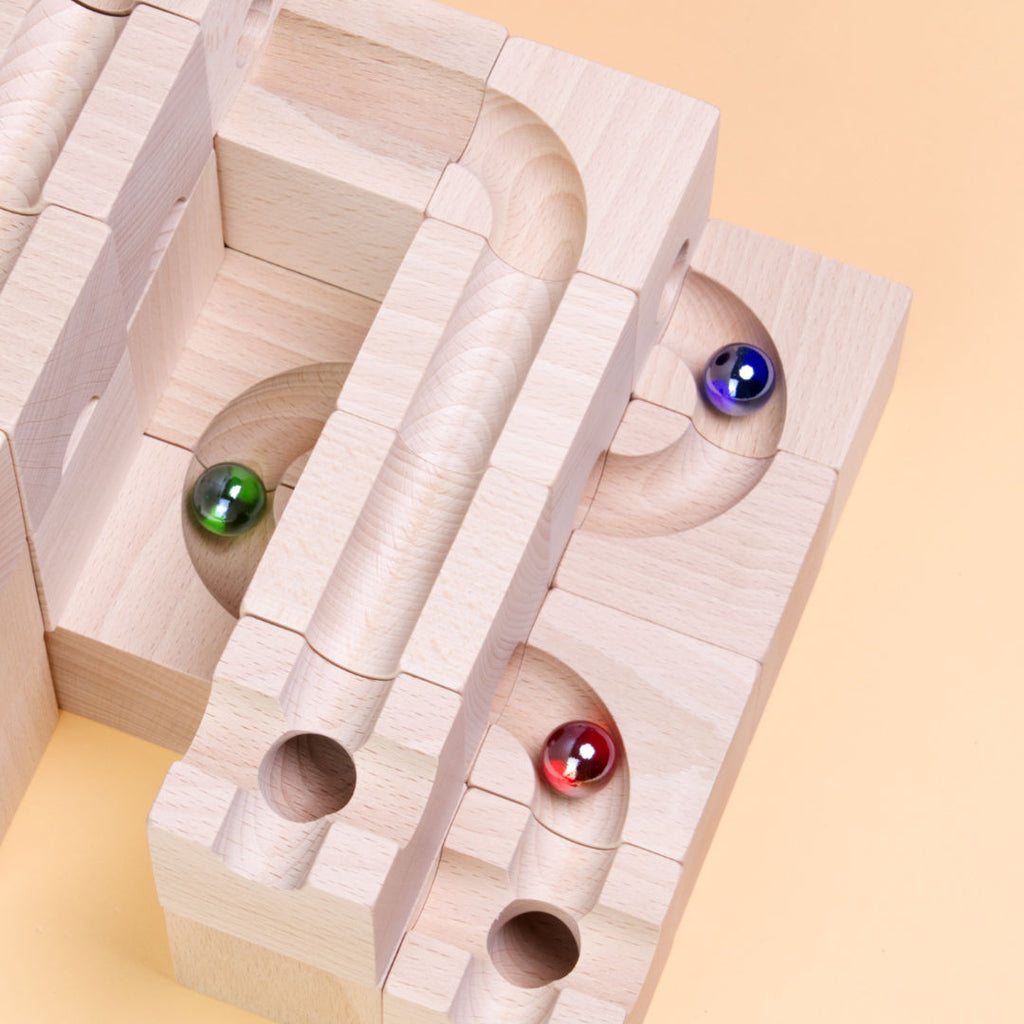 Nahaufnahme einer Murmelbahn von Cuboro des Standart Sets 32 mit den Murmeln blau, rot und grün.