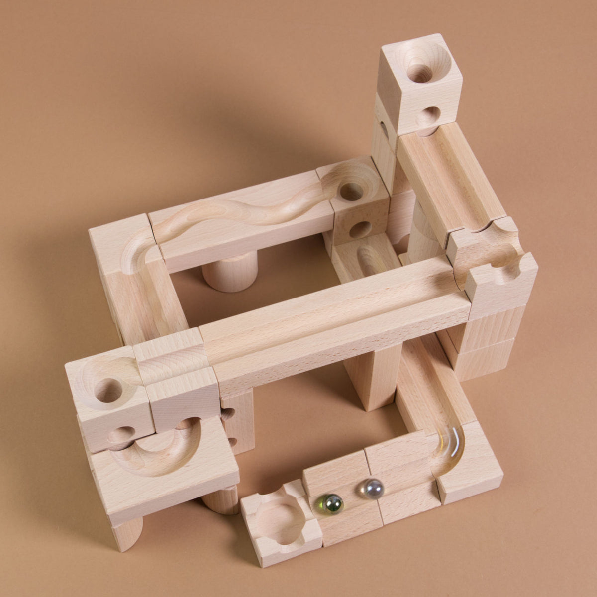 Murmelbahnaufbau mit dem Standart Set 32 von Cuboro aus Naturholz mit einer grünen und weißen Murmel.