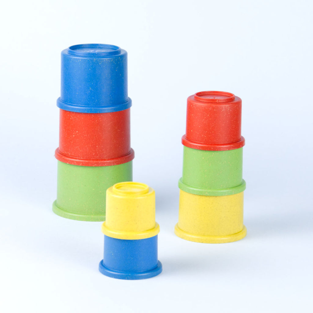 Drei verschieden große Stapelbecher Türme. Becher in den Farben grün, rot, blau und gelb.