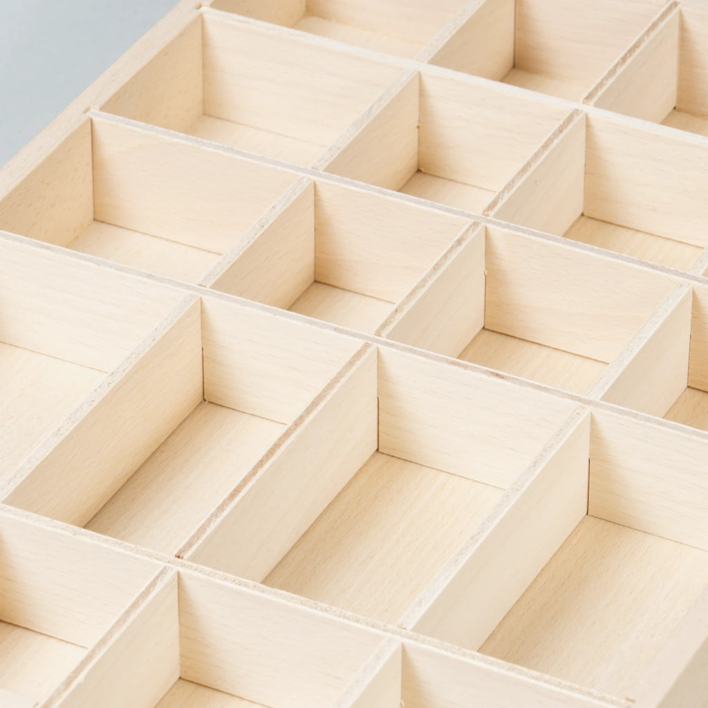 Die Detailsansicht der Sortierbox Tinker Tray aus Naturholz mit vielen verschieden großen Fächern zum Sammeln, Ordnen und Aufbewahren von Spielzeug, hier noch ungefülllt zu sehen.