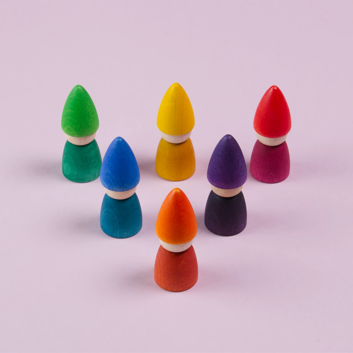 Sechs Figuren in grün, gelb, rot, blau, lila und orange, sind in einem Dreieck mit nach unten zeigender Spitze angeordnet. Alle haben kein Gesicht und sind von Grapat gefertigt.