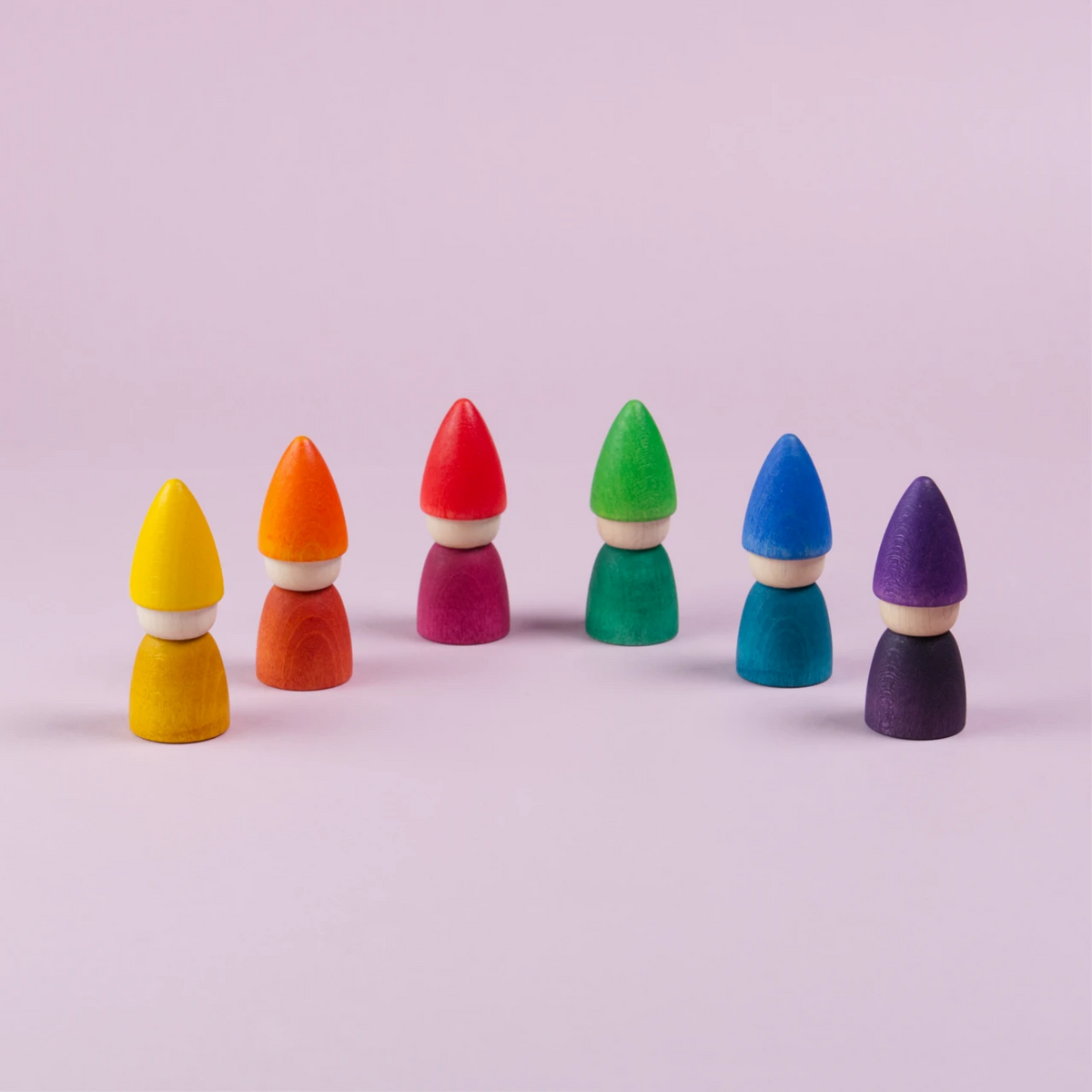 Sechs Figuren mit einer spitzen Mütze von Grapat hergestellt sind mit nach vorne hin geöffnetem Halbkreis geöffnet zu sehen. In gelb, orange, rot, grün, blau und lila.