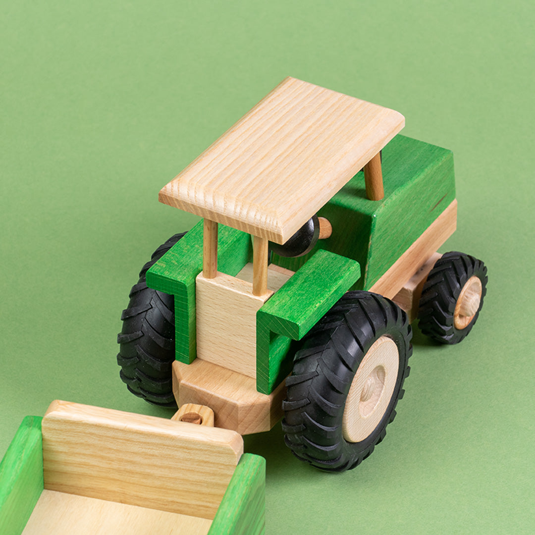 Draufsicht eines grünen, lenkbaren Traktors von Beck mit Anhänger.