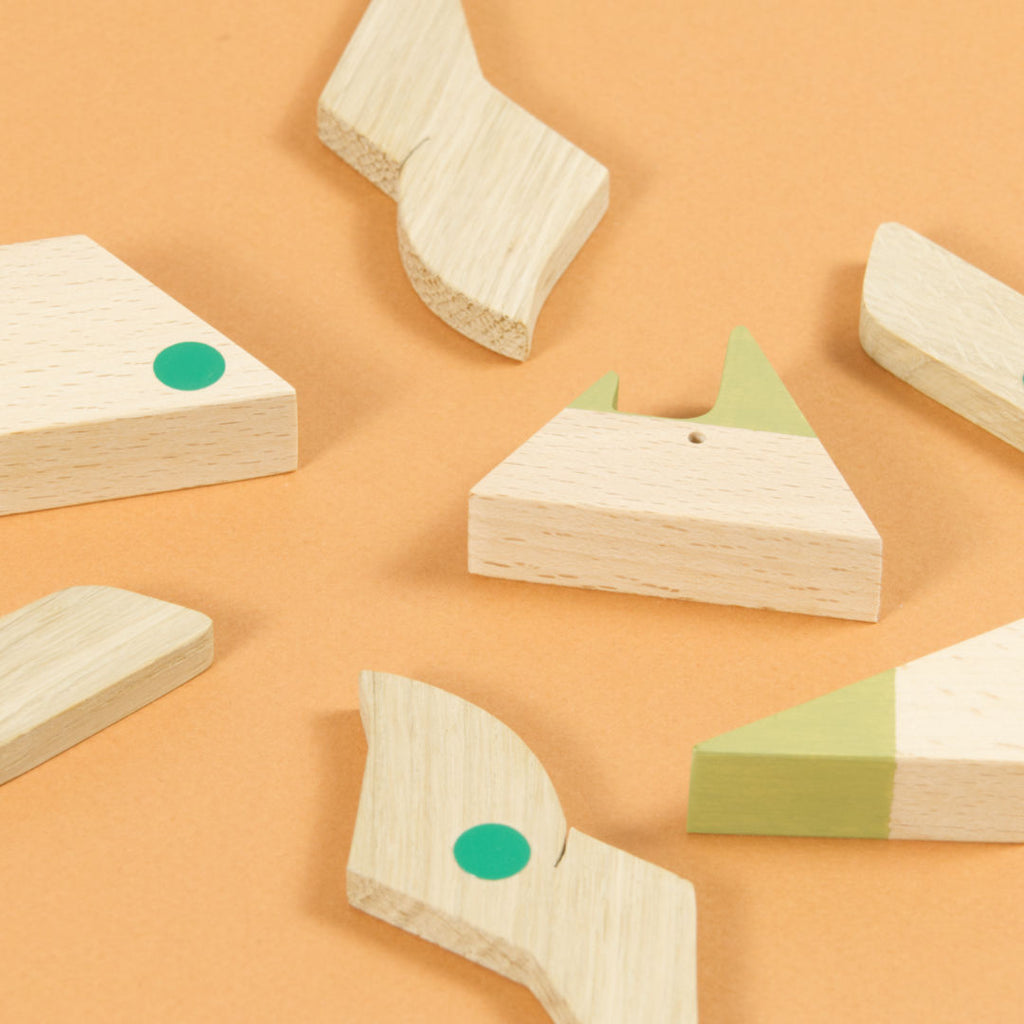 Einzelteile des Triceratops Puzzles aus Holz, magnetische Punkte sind grün markiert.