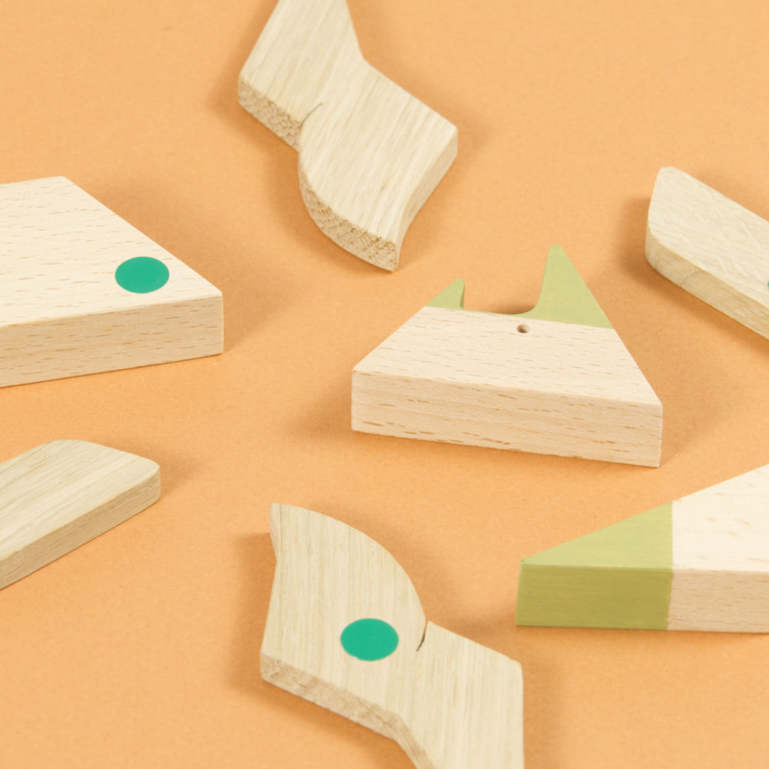 Einzelteile des Triceratops Puzzles aus Holz, magnetische Punkte sind grün markiert.