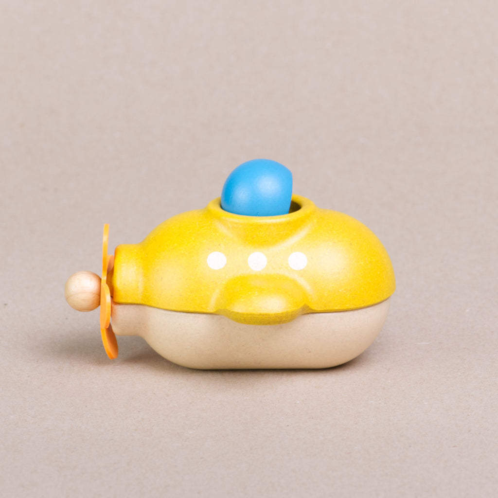 Seitenansicht des gelben U-Boots von Plan Toys mit herausnehmbaren Insassen in blauem Taucheranzug und gelber Taucherbrille. Der Taucher schaut nach vorne.