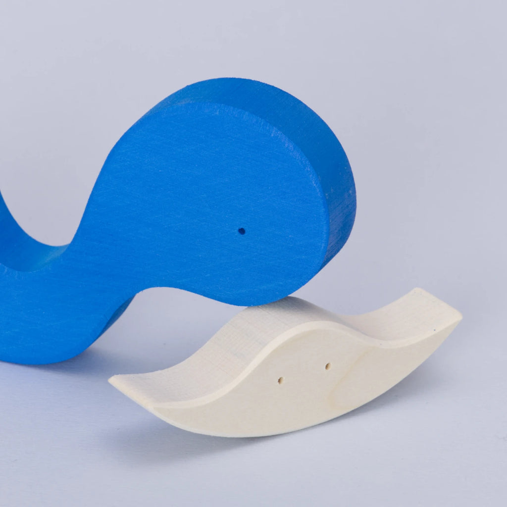 Das zweiteilige Baby Puzzle aus Holz von Goki Evolution mit dem Namen. Als der Wal einen Freund fand. Die Puzzleteile sind separiert und das größere blaue Teil liegt versetzt auf dem kleineren weißen Teil. Das große Teil ist ein blauer Wals und das kleine Puzzleteil ist ein weißer schwimmender Rochen.