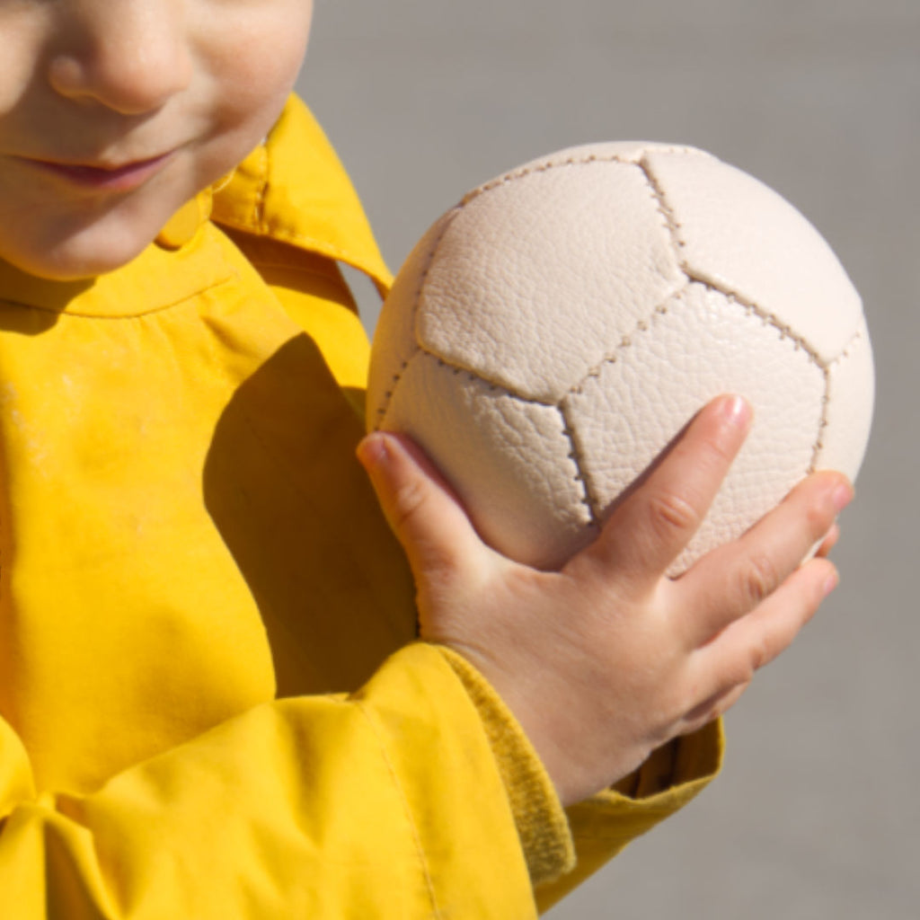 Der Ziegenlederball von Lautenbach wir von einem Kind in der Hand gehalten.