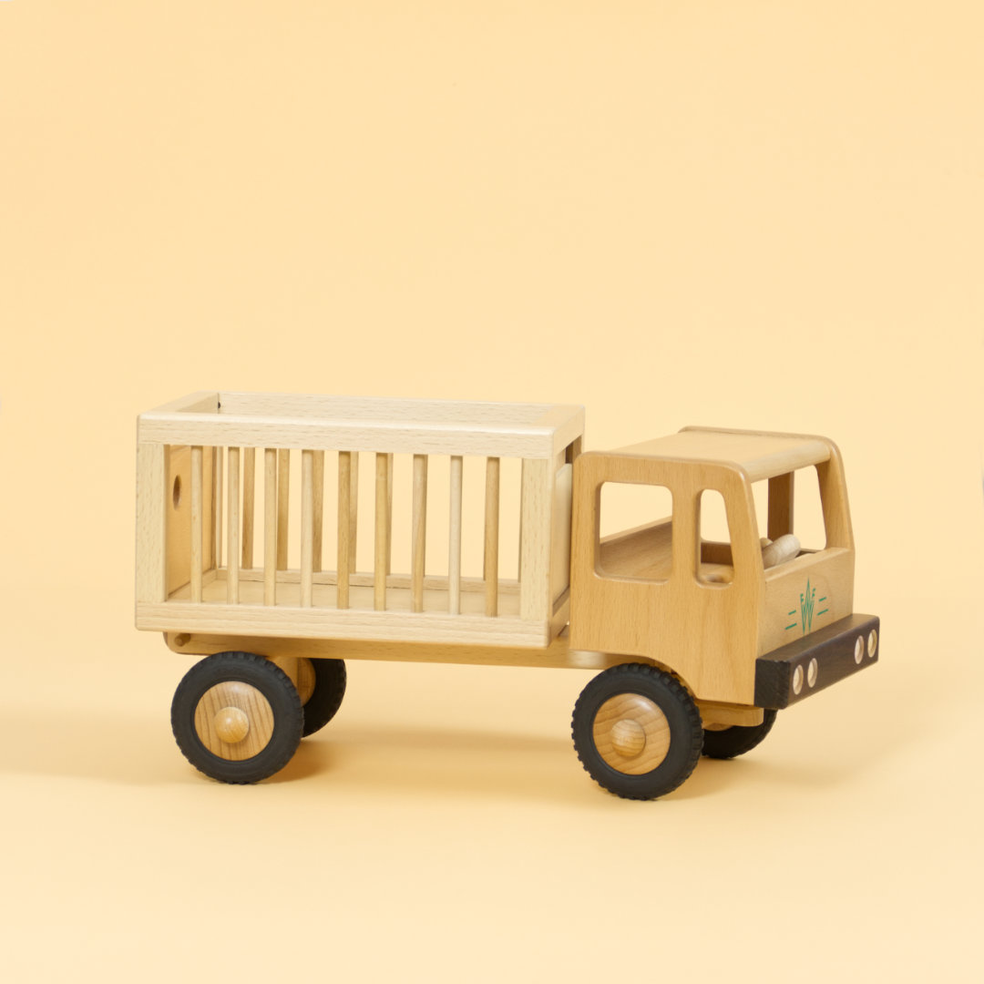 Holzfahrzeug Zirkuswagen für Tiere aus naturlackiertem Buchenholz und Reifen aus Vollgummi, aufgeteilt in Fahrerkabine vorne und Anhänger mit Gitterstäben an der Seite hinten