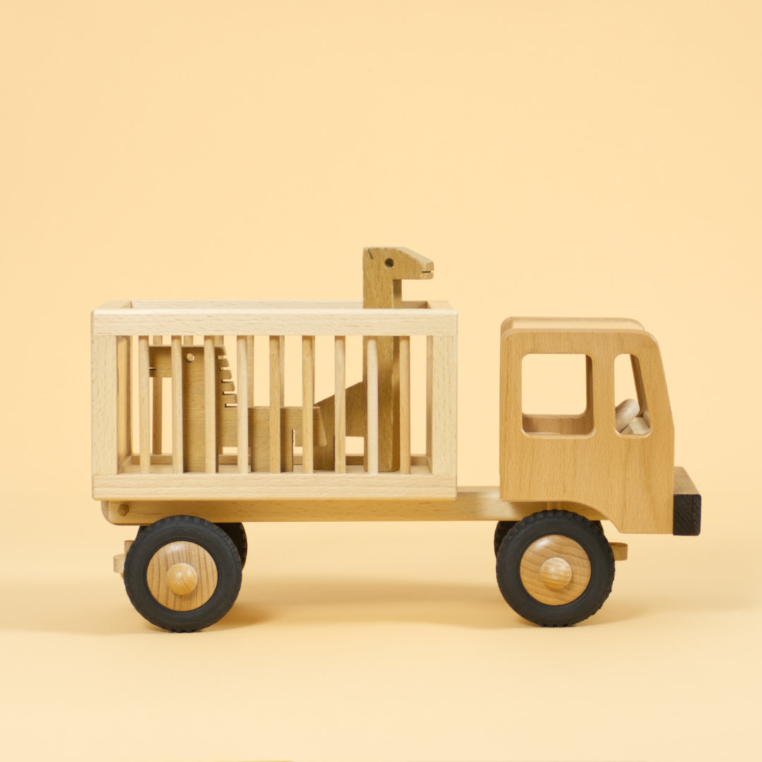 Holzfahrzeug Zirkuswagen für Tiere aus naturlackiertem Buchenholz und Reifen aus Vollgummi, Seitenansicht mit zwei Holztieren im Anhänger
