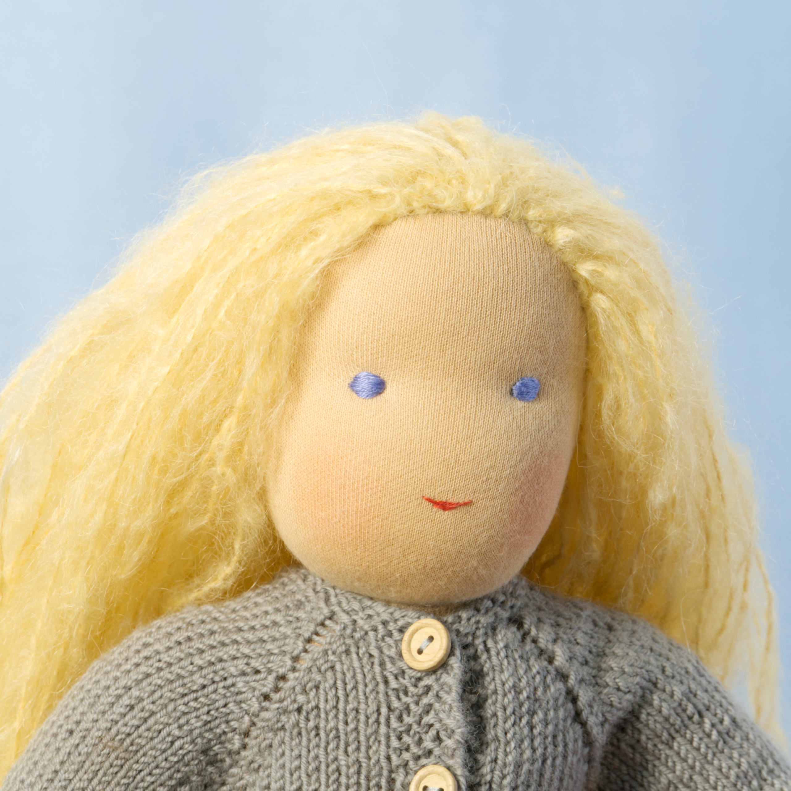 Stoffpuppe blonde Haare lang Puppe mit hellem Hautton nach Waldorf-Art, offene lange blonde Haare, gekleidet in grauen Strickanzug