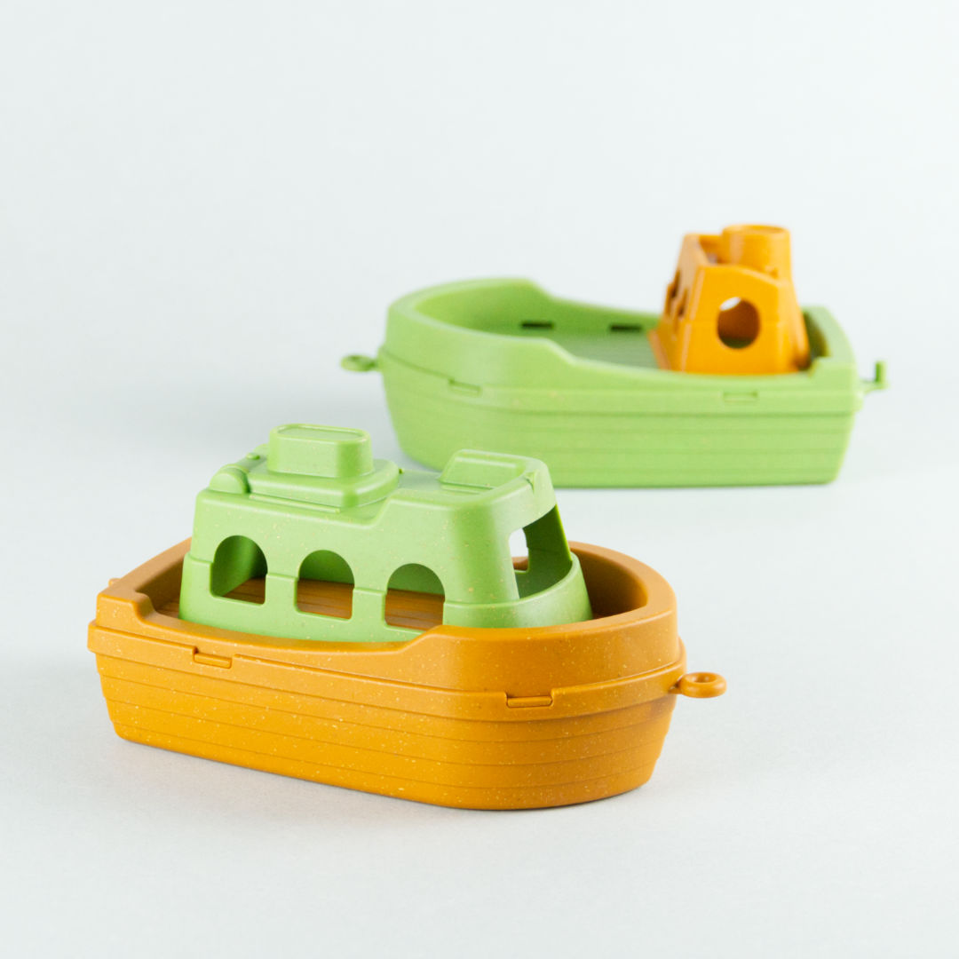 Antibakterielles Spielboot aus Kunststoff und Holz Gemisch, im Hintergrund ein zweites Spielzeug Boot