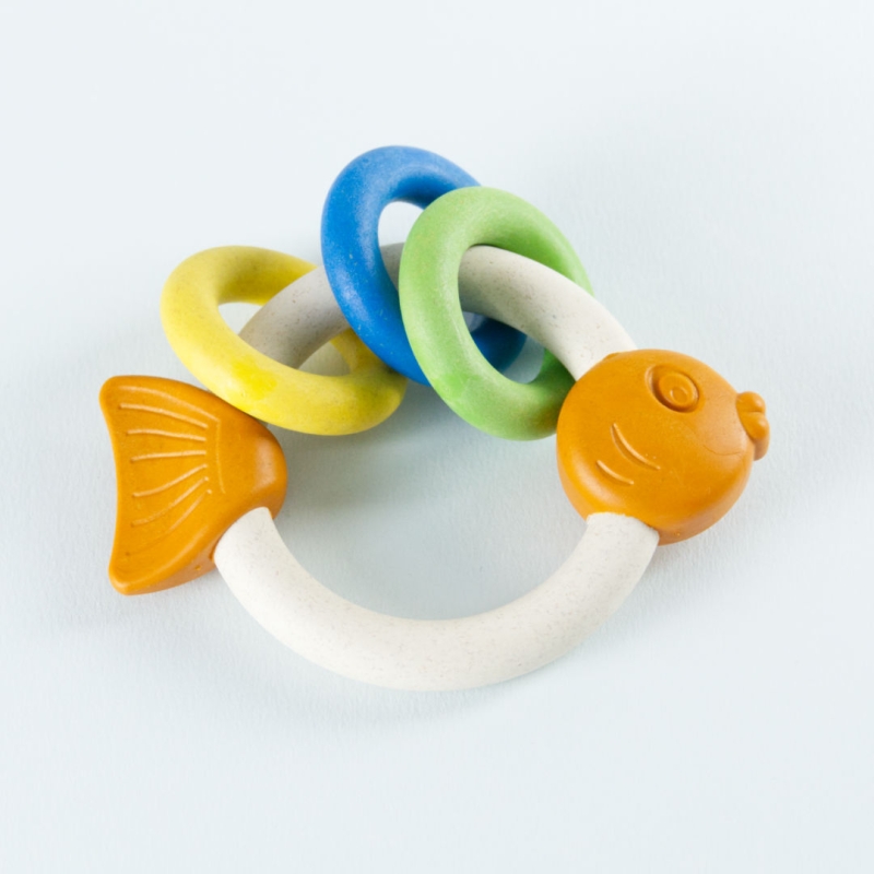 Antibakterielles Babyspielzeug Rasselring in Fischoptik. Drei kleine Ringe schmücken den großen Rassel Ring in Gelb, Blau und Grün.
