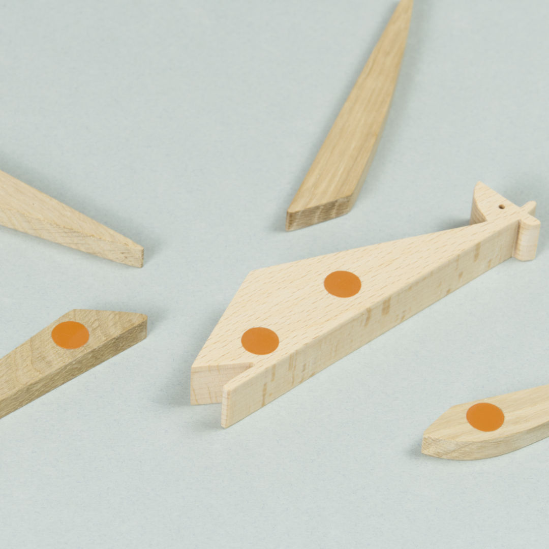 Einzelteile des Giraffen Puzzles aus Holz, magnetische Punkte sind orange markiert.