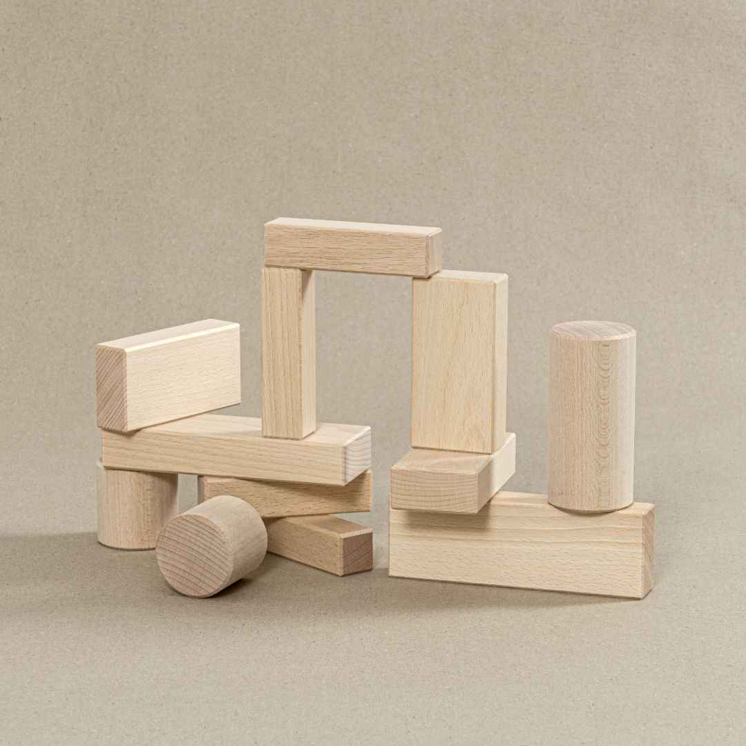 Bausteine aus Holz in rechteckiger sowie runder Form.