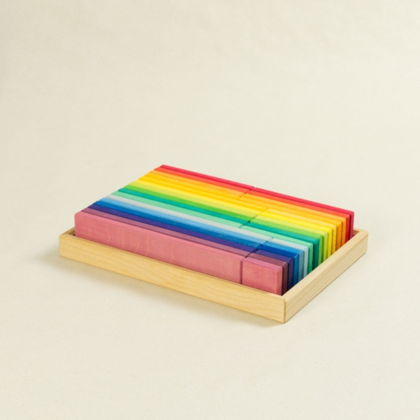 Regenbogen farbene Bauklötze in unterschiedlichen Längen.