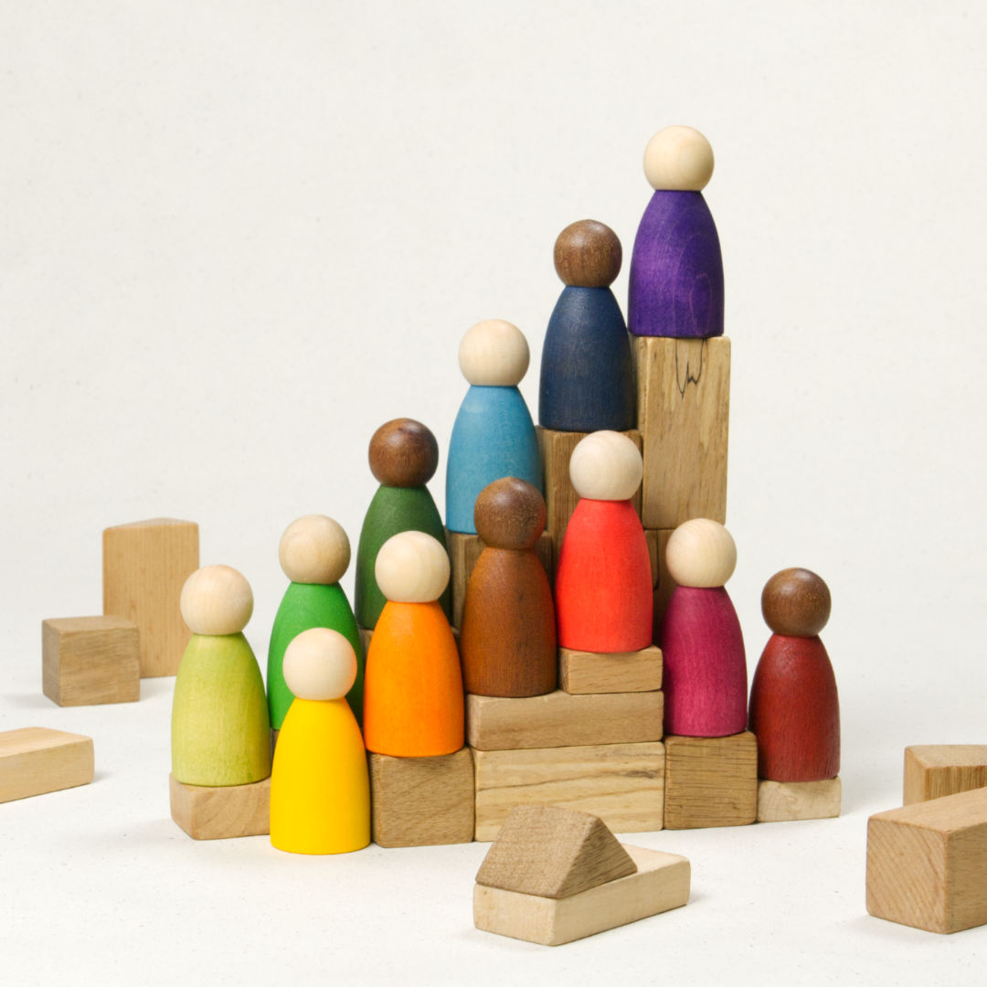 Komposition aus zwölf gleichförmigen Holzfiguren mit verschiedenen Hautfarben und Körperfarben.