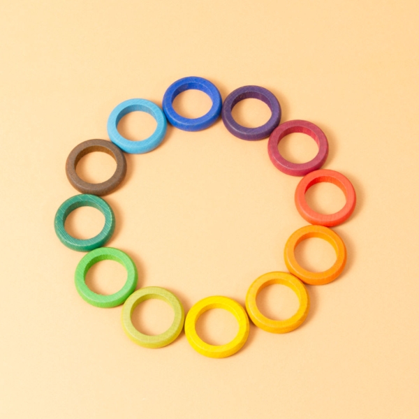 12 verschieden farbige Holzringe in einem Kreis angeordnet.