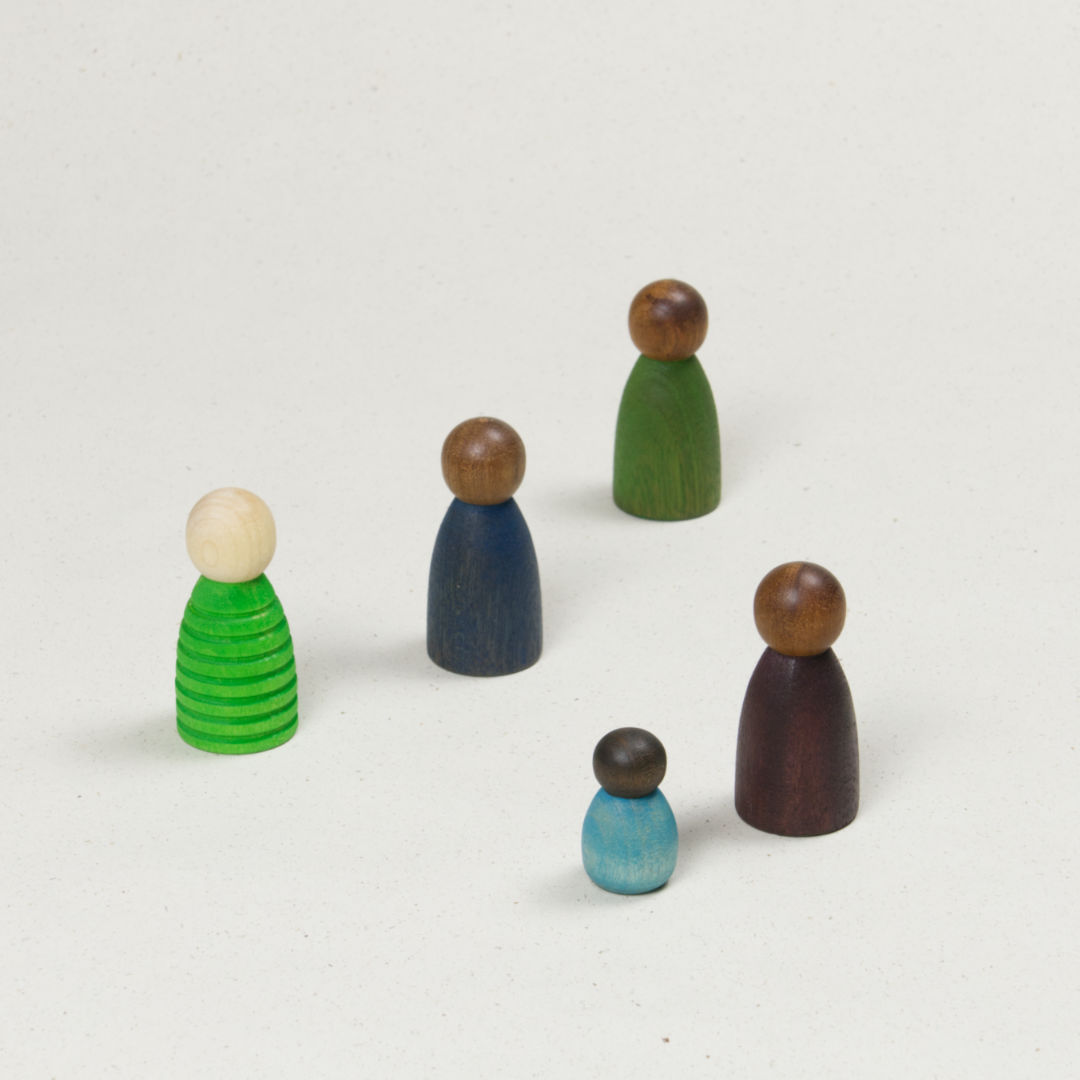 Fünf unterschiedlich geformte Holzfiguren mit verschiedenen Hautfarben in Grün, Blau und Lila.
