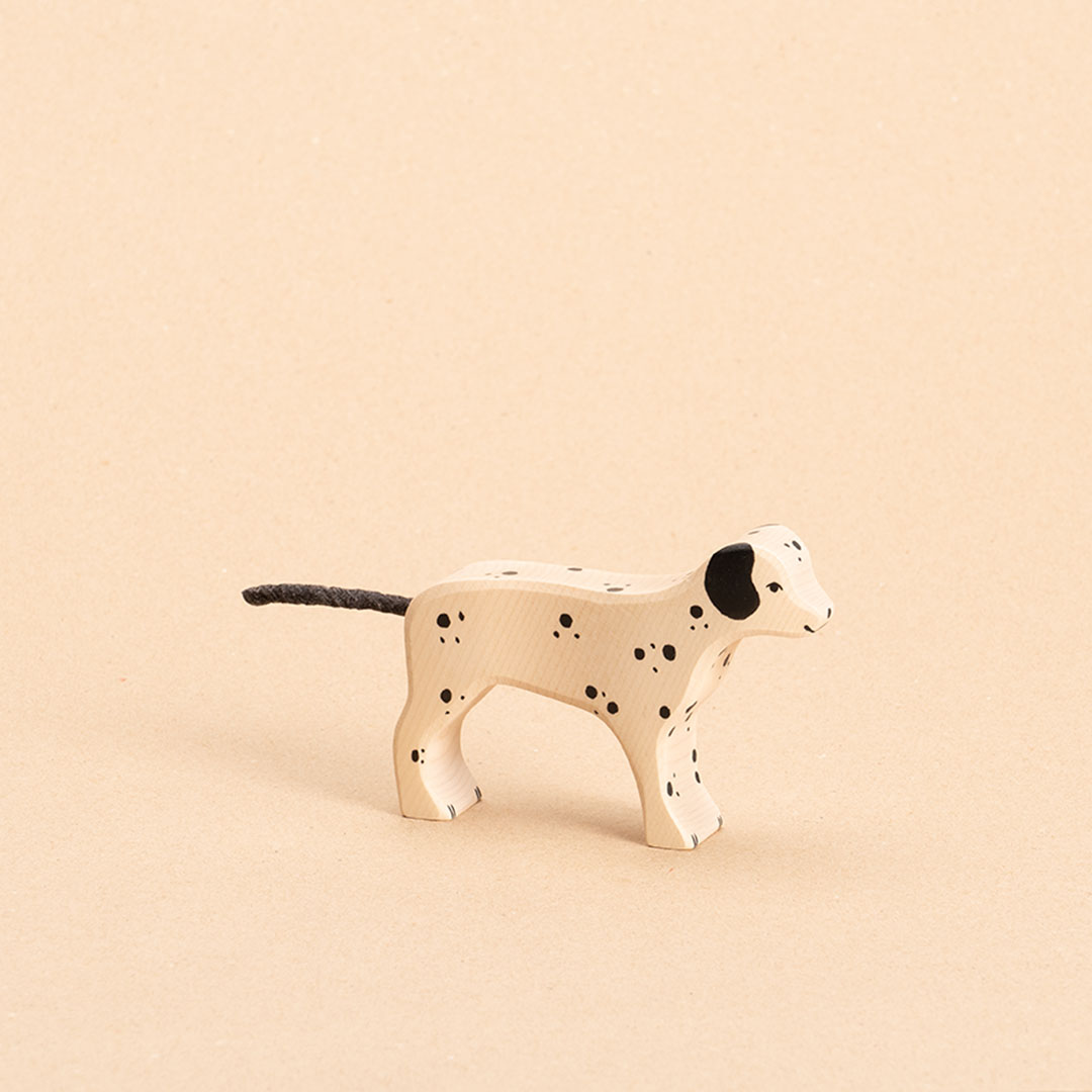 Dalmatiner aus Holz. Weiß bemalt mit schwarzen Punkten und Ohren. Nach rechts schauend