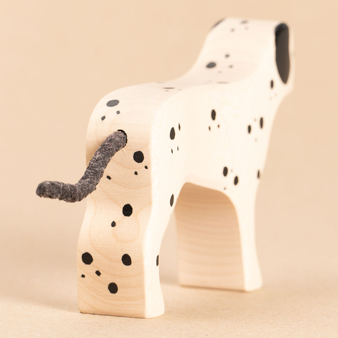 Dalmatiner aus Holz. Weiß bemalt mit schwarzen Punkten und Ohren. Nahaufnahme von Hinten, der Dalmatiner ist mit dem Rücken zu uns gedreht