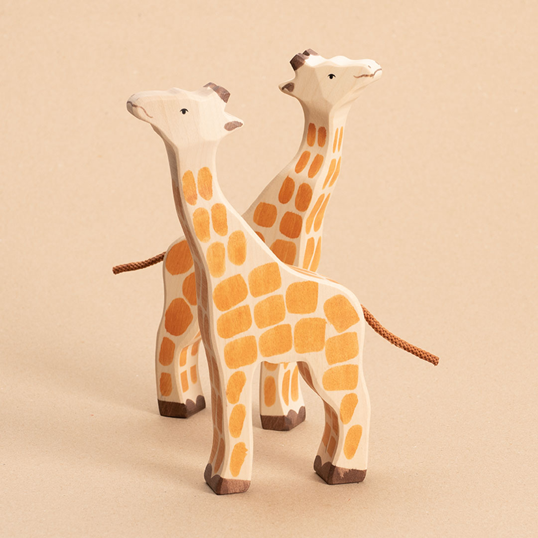 zwei Giraffen aus Holz, bemalt. Eine schaut nach Links die andere nach Rechts