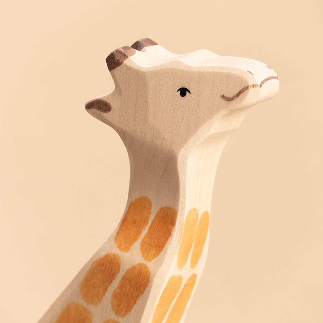 Giraffe aus Holz, bemalt. Nahaufnahme vom Gesicht.