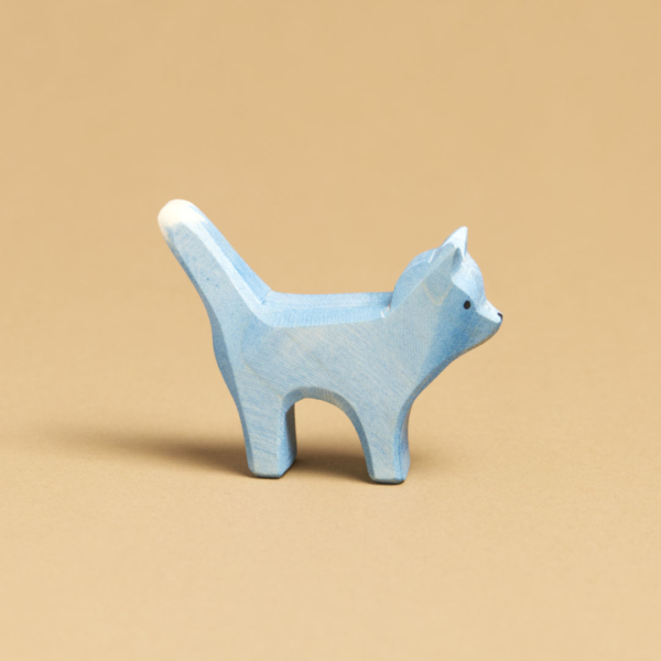 Eine blaue Katze, im Profil nach rechts schauend, ist von Ostheimer aus Naturholz gefertigt. Ihr Schwanz und ihre Ohren sind nach oben hin gerichtet.