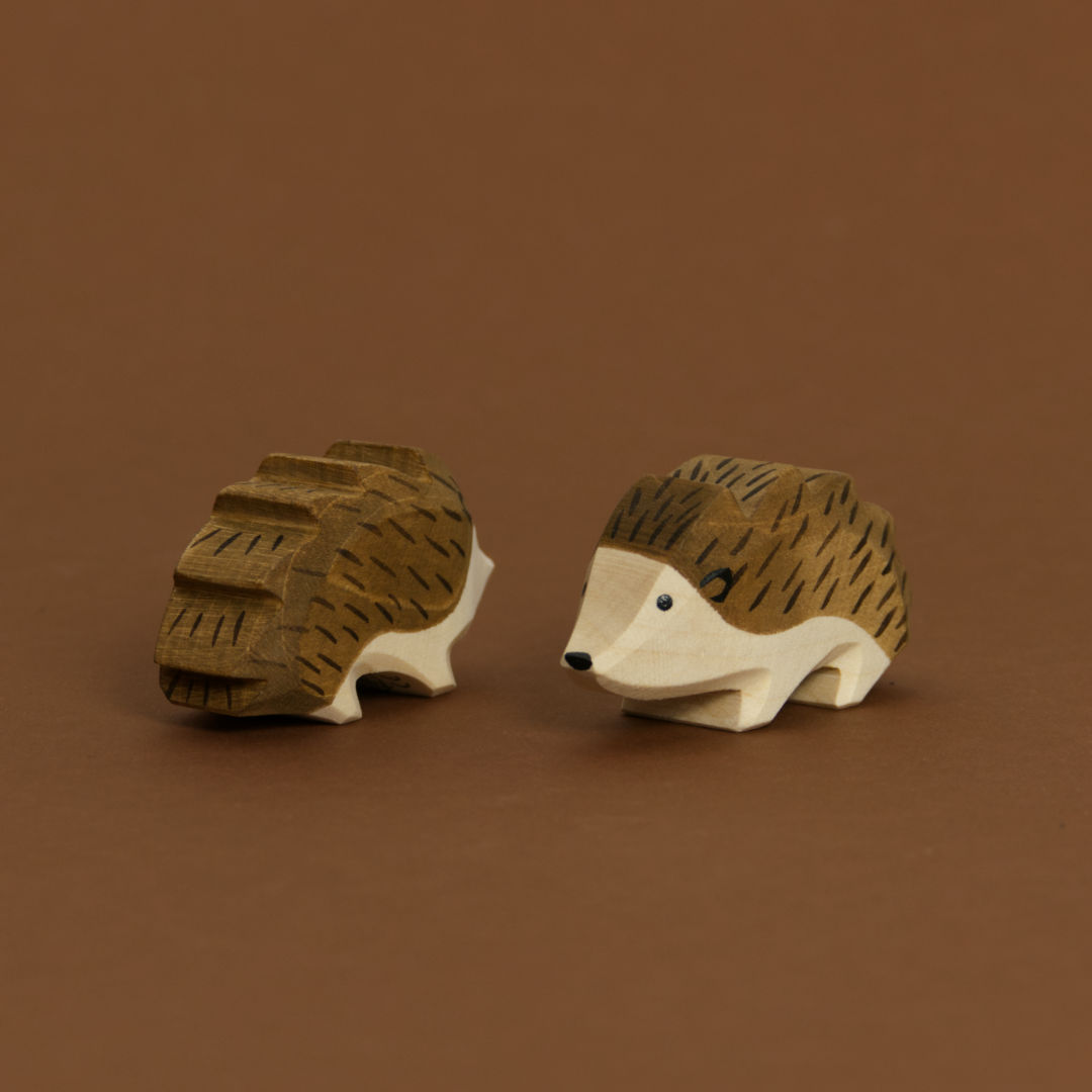 Zwei Igel von Ostheimer aus Naturholz gefertigt, beide haben dunkelbraune Stacheln und naturfarbenes Bauchfell. Der Rechte schaut nach vorne links und der Linke nach hinten rechts.