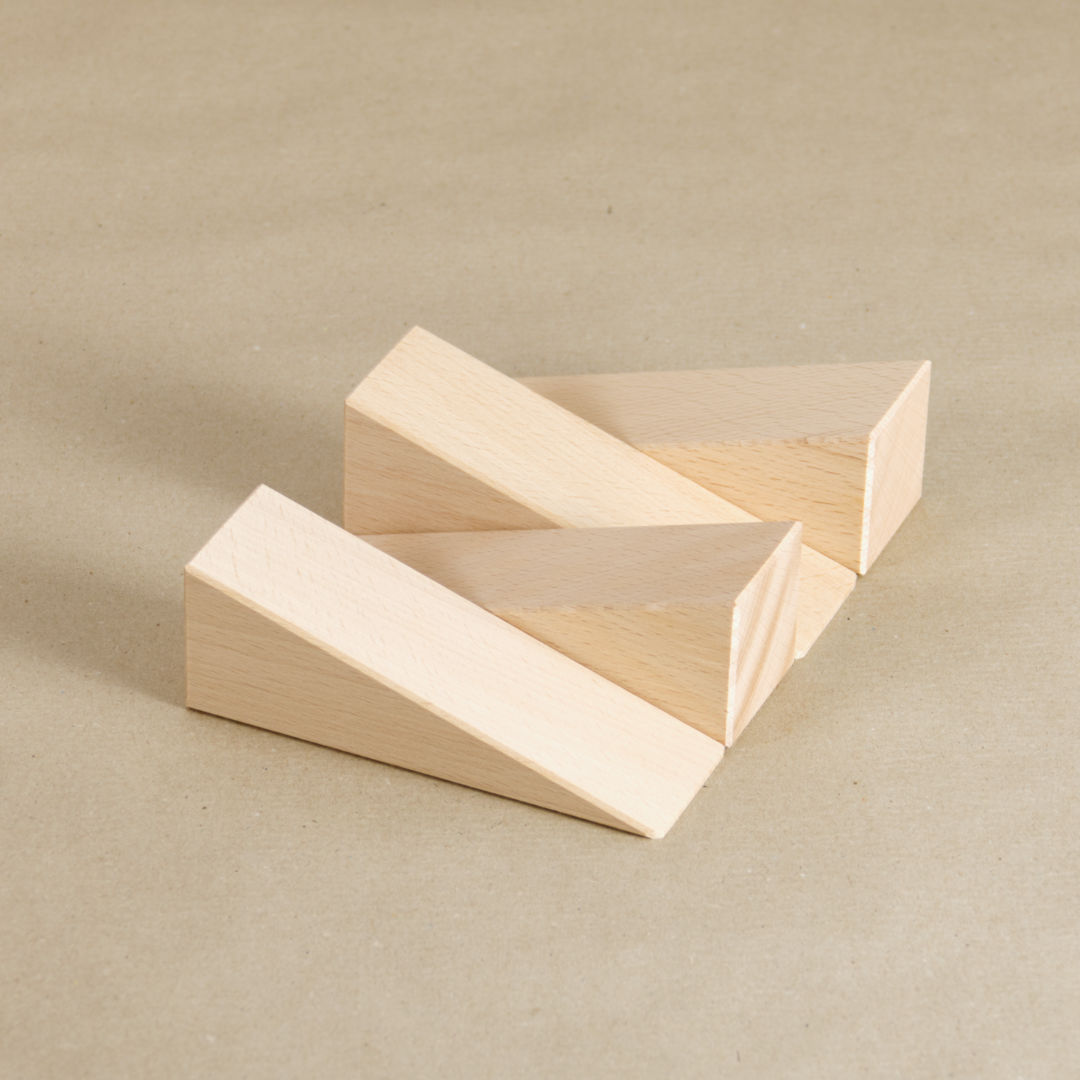 Komposition aus 4 Keilen aus Naturholz von Bruderhaus Diakonie gefertigt aus dem Set Keile, zeigen abwechselnd zueinander in entgegengesetzter Richtung.