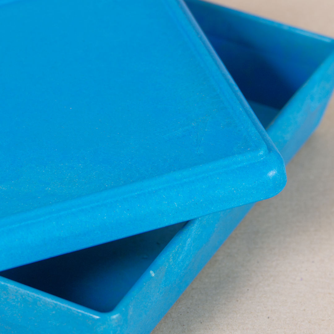 Nahaufnahme von der aus recyclebarem Material bestehende blaue Box von Wissner, mit halboffenem Deckel daliegend.