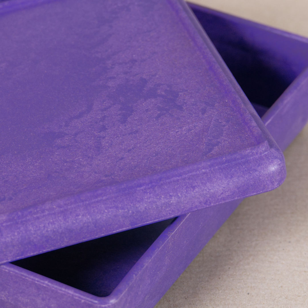 Nahaufnahme von der aus recyclebarem Material bestehende lila Box von Wissner, mit halboffenem Deckel daliegend.