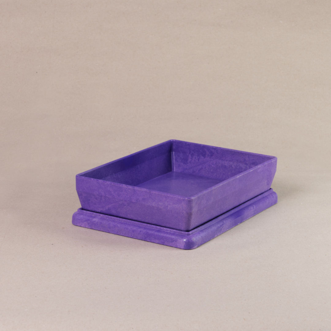 Die aus recyclebarem Material bestehende lila Box von Wissner, mit offenem Deckel daliegend.