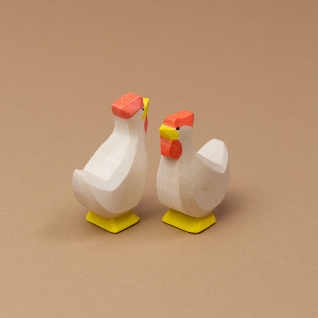 Zwei Hühner in weiss von Ostheimer gefertigt, schauen aneinander vorbei, haben gelbe Füße und Schnäbel. Das Fell ist einheitlich weiss.