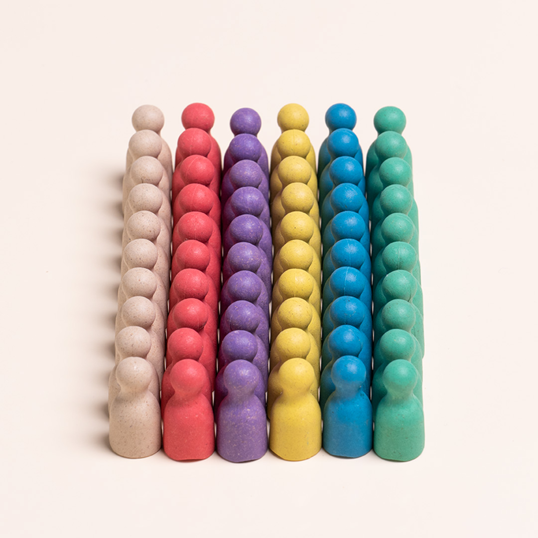 Spielfiguren in den Farben Natur, gelb, rot, lila, blau und grün aus nachhaltigem Material von Wissner stehen gemeinsam in einem Block. Jede Farbe ist 10 mal vertreten.