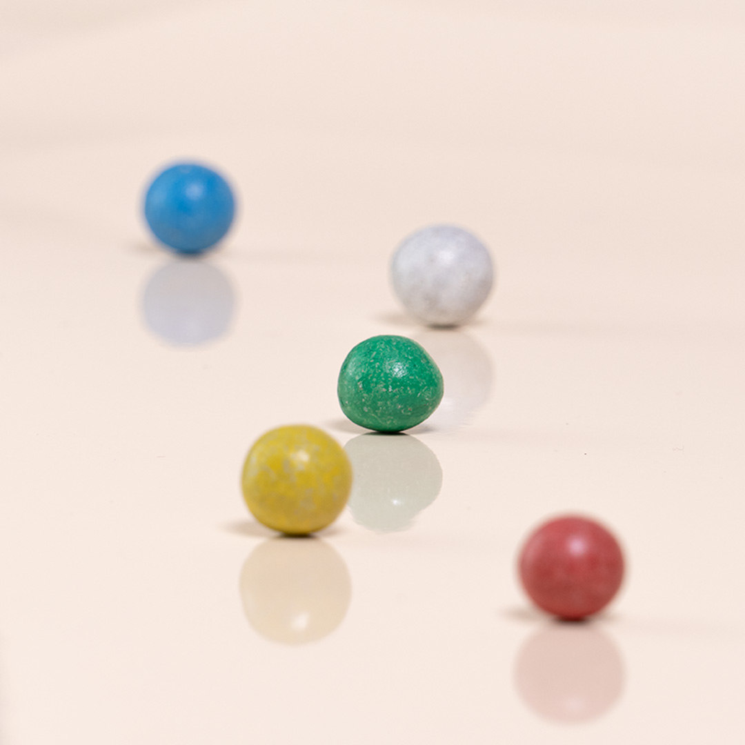 Komposition aus fünf Tonkugeln von Beck in den Farben blau, grün, gelb, rot und weiß.